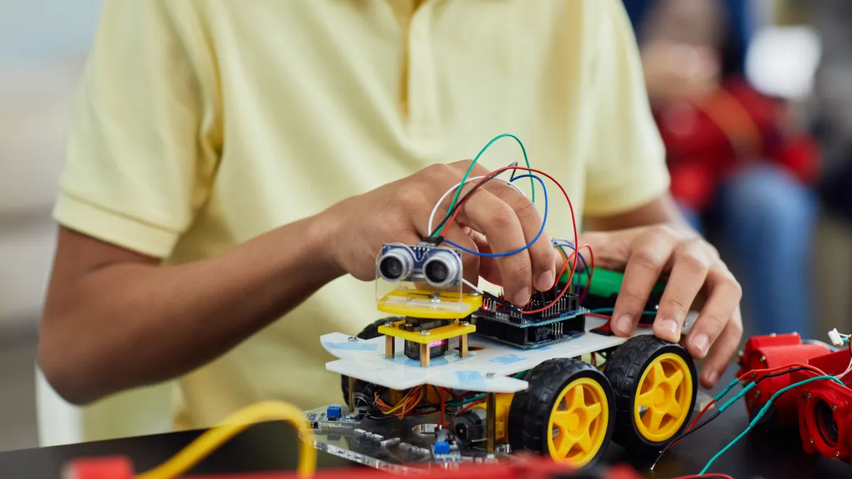 Child working on a small wheeled robot kit