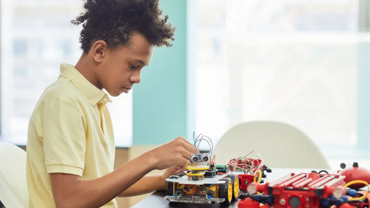 Child assembling a wheeled robotics kit